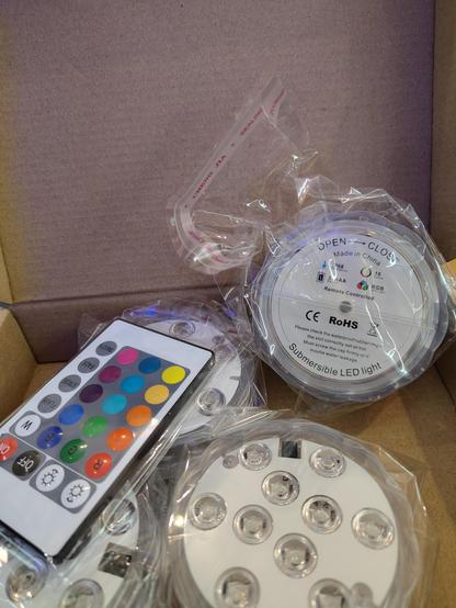Ein Paket mit 4 submersible LED-Lichtern, mehrfarbig, mit Fernbedienung. 
